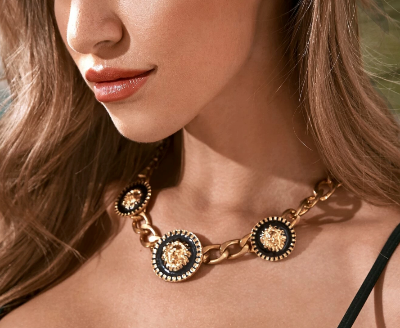 Dame draagt Coin geschakelde gouden ketting met 3 zwarte munten gegraveerd met gouden leeuwenkop