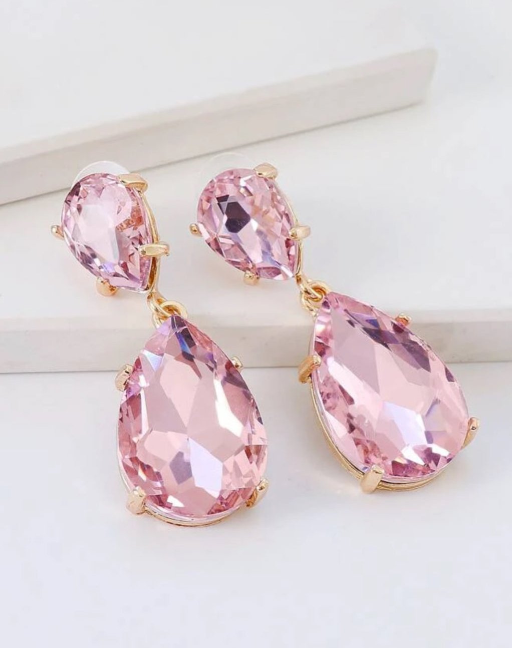 Bengelende drop oorbellen met roze ingelegde kristallen omring door gouden rand Drop earrings