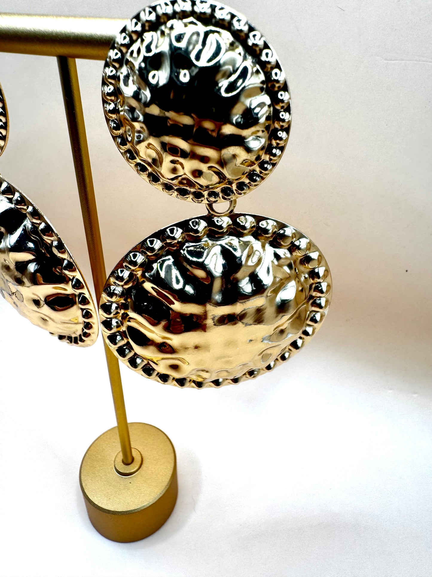 Glock oorbellen goudkleurige oorbellen met ronde gouden platen onder elkaar met structuur effect