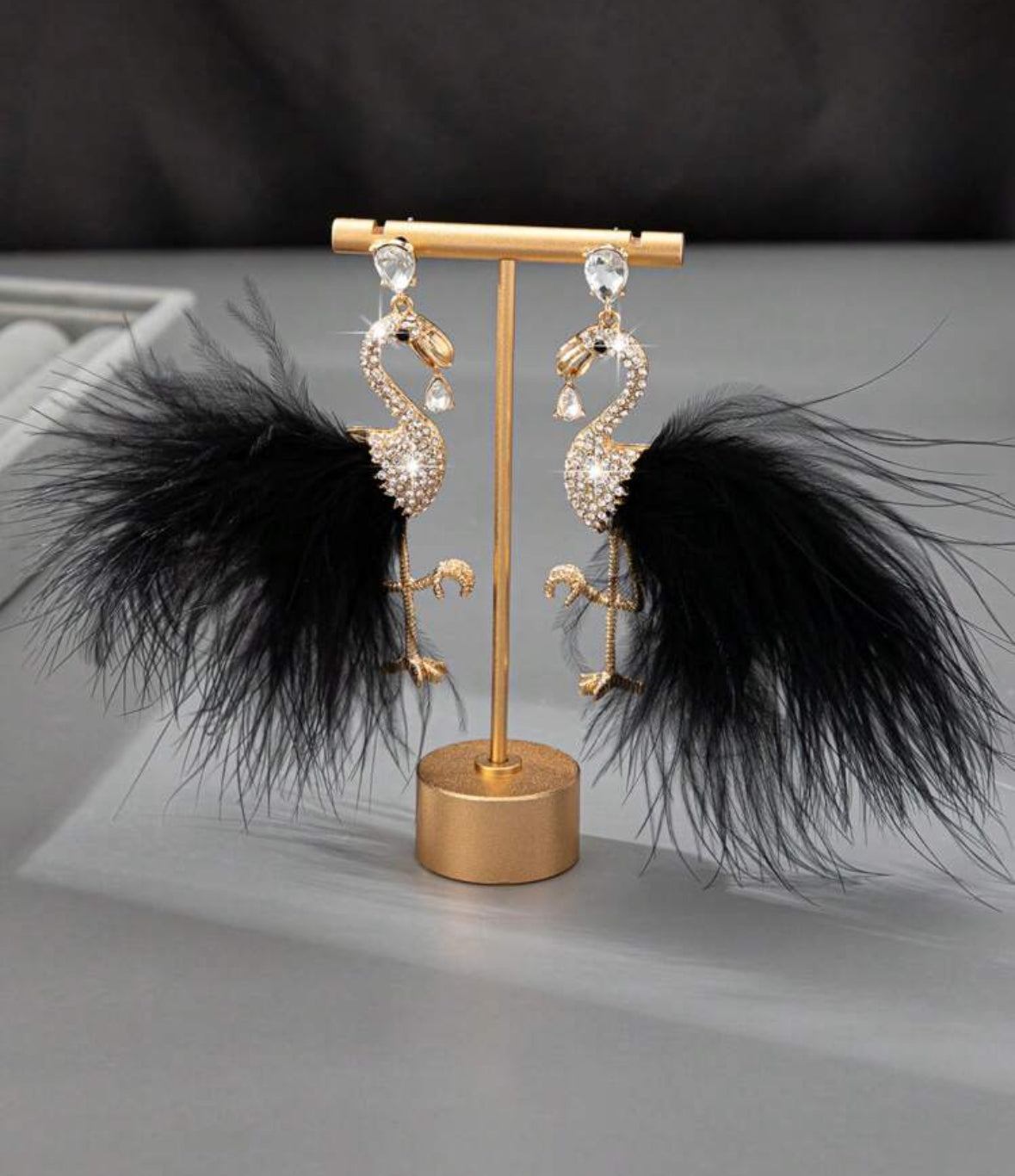 Flamingo oorbellen met goud en ingelegde strass stenen voorzien van zwarte veren staart