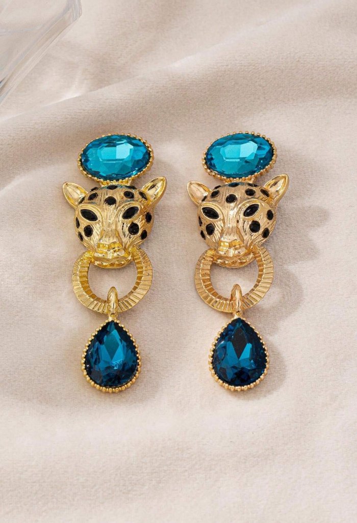 Leopard gouden oorbel met blauwe bungelende steen onder en boven en tijgerkop met zwarte stippen
