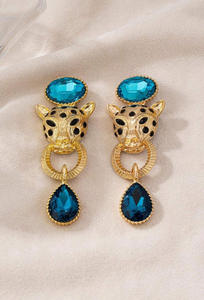 Leopard gouden oorbel met blauwe bungelende steen onder en boven en tijgerkop met zwarte stippen